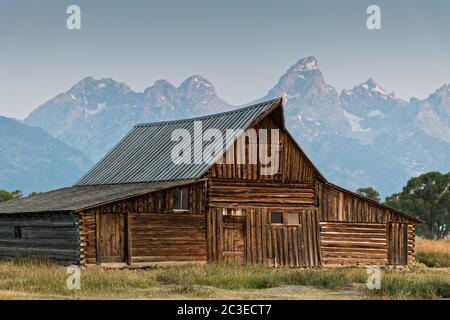 Morgensonnenaufgang über der T.A Molton Scheune im Mormon Row Historic District entlang der Antelope Flats mit den Grand Teton Bergen hinter dem Grand Teton National Park, Wyoming. Stockfoto