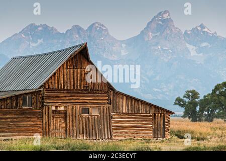 Morgensonnenaufgang über der T.A Molton Scheune im Mormon Row Historic District entlang der Antelope Flats mit den Grand Teton Bergen hinter dem Grand Teton National Park, Wyoming. Stockfoto