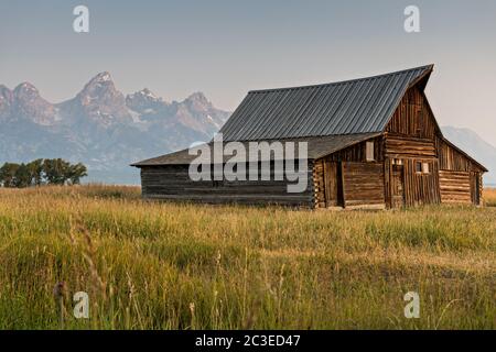 Morgensonnenaufgang über der T.A Molton Scheune im Mormon Row Historic District entlang der Antelope Flats mit den Grand Teton Bergen hinter dem Grand Teton National Park, Wyoming. Stockfoto