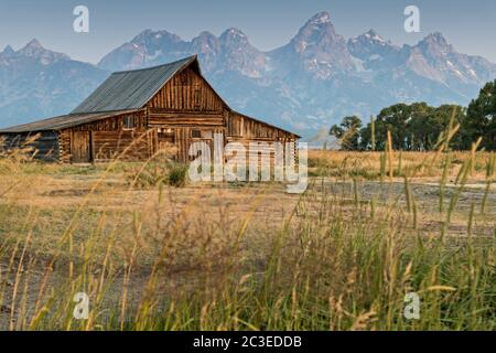 Morgensonnenaufgang über der T.A Molton Scheune im Mormon Row Historic District entlang der Antelope Flats mit den Grand Teton Bergen hinter dem Grand Teton National Park, Wyoming. Stockfoto