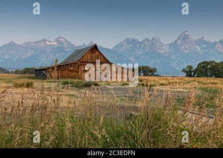 Morgensonnenaufgang über der T.A Molton Scheune im Mormon Row Historic District entlang der Antelope Flats mit den Grand Teton Bergen hinter dem Grand Teton National Park, Wyoming. Stockfoto