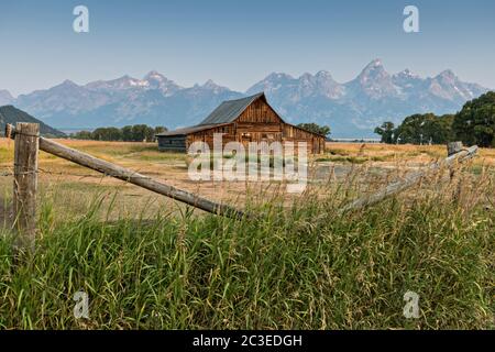 Morgensonnenaufgang über der T.A Molton Scheune im Mormon Row Historic District entlang der Antelope Flats mit den Grand Teton Bergen hinter dem Grand Teton National Park, Wyoming. Stockfoto