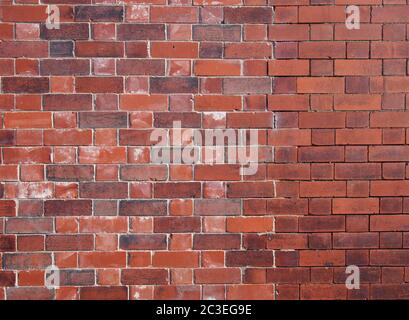 Eine alte reparierte geflickte Außenwand aus roten Ziegeln Stockfoto