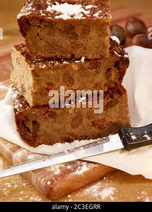 Brotscheiben Pudding und Puderzucker auf fettfestem Papier als ob warten, um zum Mittagessen eingewickelt werden, Lebensmittel Stillleben Stockfoto