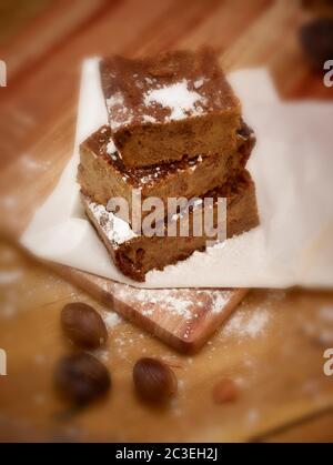 Brotscheiben Pudding und Puderzucker auf fettfestem Papier als ob warten, um zum Mittagessen eingewickelt werden, Lebensmittel Stillleben Stockfoto