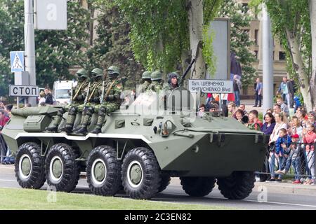 Donezk, Volksrepublik Donezk, Ukraine, 9. Mai 2018. Ein gepanzerter Personalträger mit getarnten Soldaten an der Spitze bewegt sich entlang der Artyomy Street Stockfoto