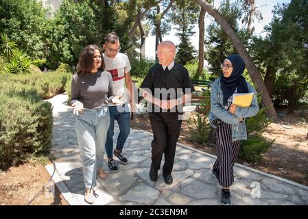 Bruder Peter Bray, der Vizekanzler der Universität Bethlehem, spricht mit einigen seiner Studenten auf dem Campus. Stockfoto