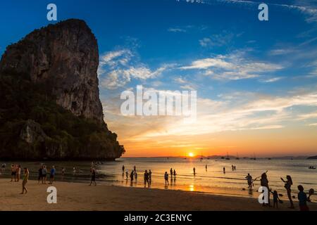 Krabi, Thailand - 11. Februar 2019: Railay Strand, schöner Sonnenuntergang und blauer, hoher Wolkenhimmel, Berg links. Viele Touristen genießen die Sonne auf einer tropischen Insel Stockfoto