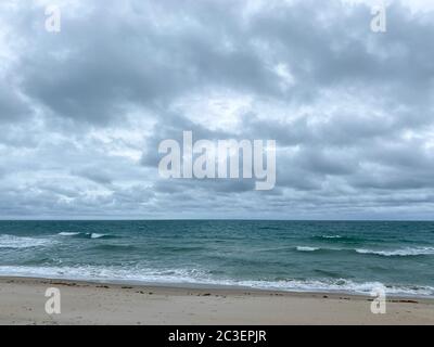 Meereswellen lappen an einem schönen sonnigen Tag entlang der Küste auf North Hutchinson Island Florida am Strand. Stockfoto