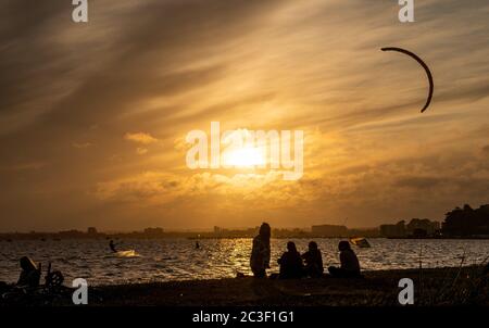 Poole, Großbritannien. Juni 2020. Der Sonnenuntergang sorgt für einen feurigen Himmel, während die Menschen die Abendaktivitäten im Sandbanks in Poole, Dorset, genießen. Kredit: Richard Crease/Alamy Live Nachrichten Stockfoto