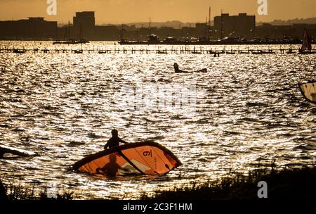 Poole, Großbritannien. Juni 2020. Der Sonnenuntergang sorgt für einen feurigen Himmel, während die Menschen die Abendaktivitäten im Sandbanks in Poole, Dorset, genießen. Kredit: Richard Crease/Alamy Live Nachrichten Stockfoto