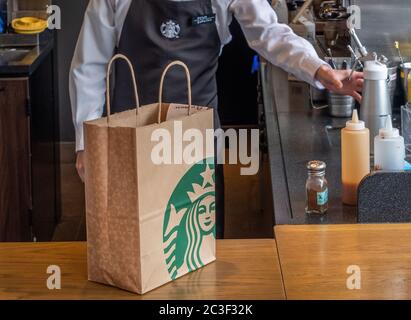 Barista, der Gäste im Starbucks Coffee House, Nakameguro Station, Tokio, Japan, mit einem Getränk zubereitet Stockfoto