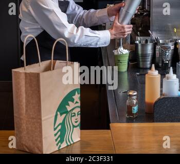 Barista, der Gäste im Starbucks Coffee House, Nakameguro Station, Tokio, Japan, mit einem Getränk zubereitet Stockfoto