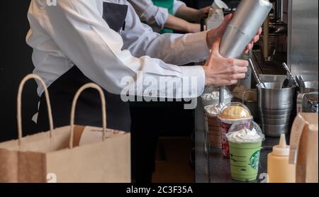 Barista, der Gäste im Starbucks Coffee House, Nakameguro Station, Tokio, Japan, mit einem Getränk zubereitet Stockfoto