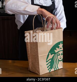 Barista, der Gäste im Starbucks Coffee House, Nakameguro Station, Tokio, Japan, mit einem Getränk zubereitet Stockfoto