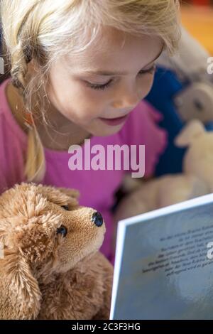 Mädchen (7) liest in einem Buch, Kiel, Deutschland Stockfoto