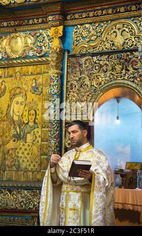 Die Rev. Androwas Bahus führt eine frühe Morgenliturgie in St. Peter und St. Paul Kirche in der Stadt Shefa-Amr, Israel. Stockfoto