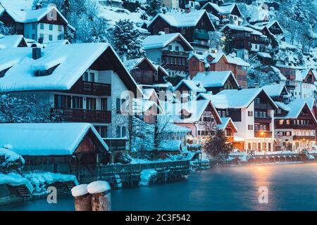 Alte Häuser in einer schönen Hallstätter Seestadt in den Alpen in mystischer Dämmerung während der blauen Stunde bei Sonnenaufgang an einem schönen kalten nebligen Tag im Winter, Österreich Stockfoto