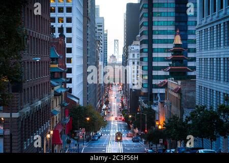 Klassische Ansicht der Innenstadt von San Francisco mit Seilbahn auf der California Street mit der berühmten Oakland Bay Bridge im Hintergrund bei Sonnenaufgang, San Francisco, Ca Stockfoto