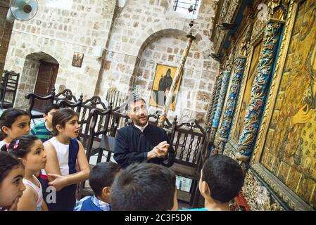 Die Rev. Androwas Bahus führt eine frühe Morgenliturgie in St. Peter und St. Paul Kirche in der Stadt Shefa-Amr, Israel. Stockfoto