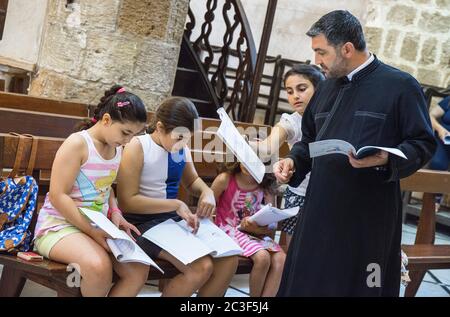 Die Rev. Androwas Bahus führt eine frühe Morgenliturgie in St. Peter und St. Paul Kirche in der Stadt Shefa-Amr, Israel. Stockfoto