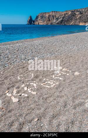 Die Inschrift auf russisch ist aus den grauen glatten Kieselsteinen auf dem Jaspisstrand, dem Kap Fiolent in Balaklava, der Stadt Sewastopol angelegt. Übersetzung: Krim Stockfoto