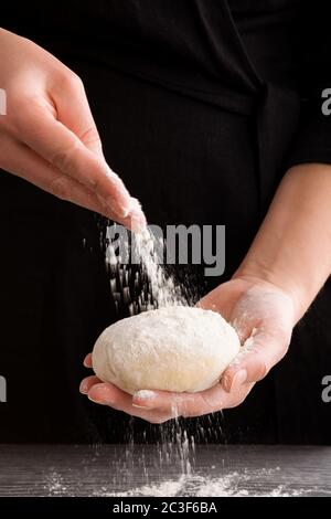 Weibliche Hände machen Teig für Pizza. Stockfoto