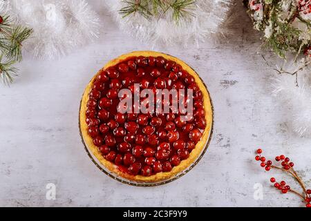 Kirschkäsekuchen mit Beeren auf der Oberseite mit Weihnachtsdekoration. Draufsicht. Stockfoto