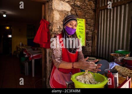 Real De Catorce, Mexiko. Juni 2020. Ein Arbeiter, der eine Gesichtsmaske als vorbeugende Maßnahme trägt, macht mexikanische Maistortillas in einem Restaurant während der Wiedereröffnung von Unternehmen nach drei Monaten der Sperre aufgrund der Coronavirus-Pandemie. Kredit: Antonio Cascio/SOPA Images/ZUMA Wire/Alamy Live Nachrichten Stockfoto