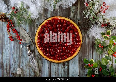 Kirschkäsekuchen mit Beeren auf der Oberseite mit Weihnachtsdekoration. Draufsicht. Stockfoto