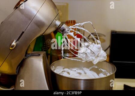 Stabiles Eiweiß mit Schlagsahne auf dem Schneebesen des elektrischen Mischers Stockfoto