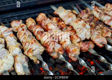 Fleisch auf Metallspieße wird mit brennender Holzkohle gegrillt. Stockfoto