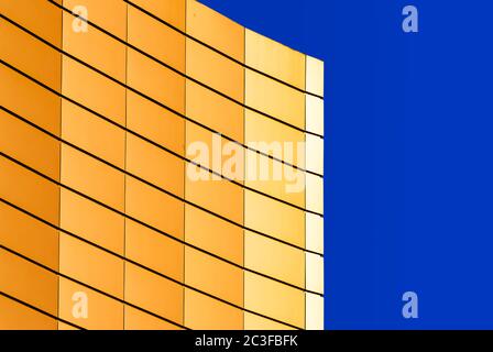 Fragment der Wand eines modernen gelben Gebäudes auf blauem Hintergrund Stockfoto