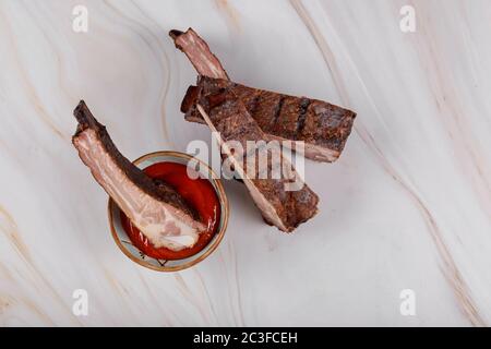 Gegrillte Rippchen mit scharfer Chili-Dipping-Sauce auf dem Tisch Stockfoto