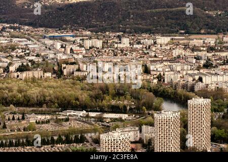 Panoramablick auf Grenoble von den umliegenden Hügeln aus, zeigt das Stadtbild, die städtische Architektur und die französischen Alpen im Hintergrund. Stockfoto