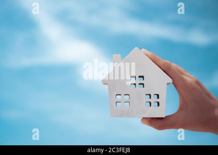 Copyspace mit Modell eines kleinen Hauses, dass Frau hält es Hintergrund. Traum Familienleben Konzept. Stockfoto