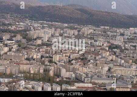 Panoramablick auf Grenoble von den umliegenden Hügeln aus, zeigt das Stadtbild, die städtische Architektur und die französischen Alpen im Hintergrund. Stockfoto