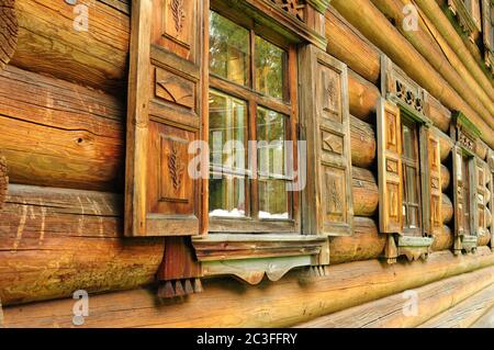 Blockwand mit alten Holzfenstern im russischen Nationalstil Stockfoto