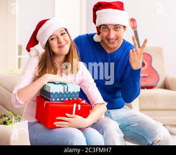 Junges Paar Weihnachten zu Hause feiern. Stockfoto