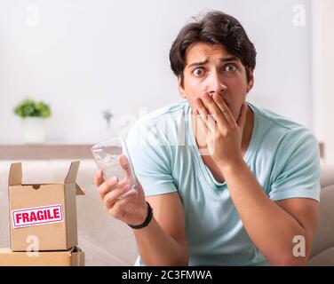 Mann öffnen zerbrechliches Paket aus dem Internet bestellt Stockfoto