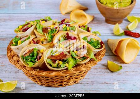 Bunte Tortilla Kegel gefüllt mit Fajita in Weidenkorb. Mexikanisches Essen. Stockfoto