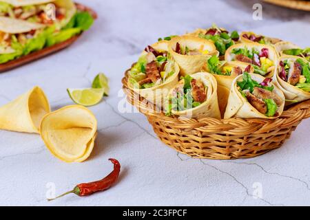 Bunte Tortilla Kegel gefüllt mit Fajita in Weidenkorb. Mexikanisches Essen. Stockfoto