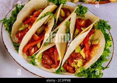 Mehl Tortillas gefüllt mit Fleisch, Bohnen und Gemüse auf weißem Hintergrund. Lateinamerikanische Küche. Stockfoto