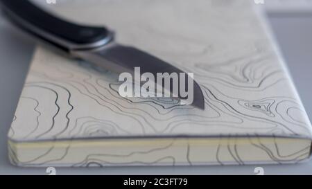 Isolierte Nahaufnahme eines einzelnen Messer auf einer topografischen Karte Notebook- Konzept Camping / im Freien Hintergrund- Israel Stockfoto