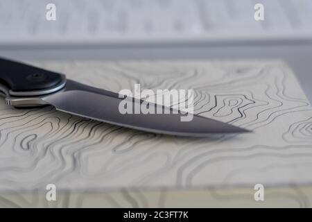 Isolierte Nahaufnahme eines einzelnen Messer auf einer topografischen Karte Notebook- Konzept Camping / im Freien Hintergrund- Israel Stockfoto