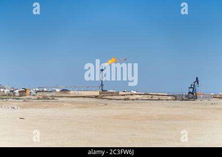 Manama / Bahrain - 10. Januar 2020: Gasförderleitung mit Feuerflamme in Ölförderanlage in der Wüste von Bahrain Stockfoto