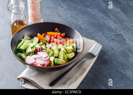 Vegane buddha Schale. Gesunder vegetarischer Salat mit Kirschtomaten, Gurken, Rettich, Avocado, Salat Stockfoto