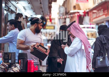 Manama / Bahrain - 10. Januar 2020: Einheimische Muslime tragen traditionelle Kleidung und einkaufen in Manama Souq, einem berühmten Touristenziel in der Hauptstadt von Bahrain Stockfoto