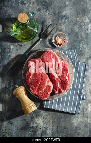 Rohes Rindersteak auf dunkelgrauem Hintergrund Stockfoto