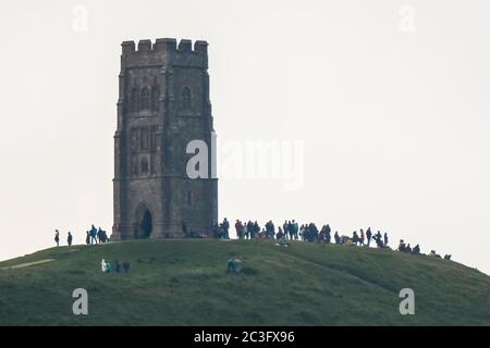 Glastonbury, Somerset, Großbritannien. Juni 2020. Wetter in Großbritannien. Viele Menschen versammelten sich auf dem Gipfel des Glastonbury Tor in Somerset, um den Sonnenaufgang über der Sommersonnenwende zu beobachten, aber der Himmel war bei Sonnenaufgang voller Wolken. Bildquelle: Graham Hunt/Alamy Live News Stockfoto